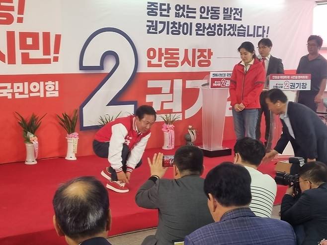 ▲ 권기창 예비후보가 무대에서 딸이 전달한 '필승의 빨간 운동화' 끈을 묶고 있다. 오종명 기자