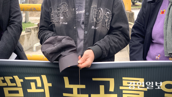 응우옌 반 뚜씨가 10일 형의 유품인 모자와 목걸이를 손에 쥐고 질의를 받고 있다. 2026.4.10 /유혜연기자 pi@kyeongin.com