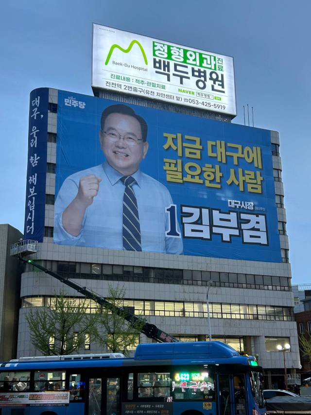 11일 더불어민주당 김부겸 대구시장 예비후보가 달서구 두류네거리 인근 선거사무소 외벽에 현수막을 걸고 있다. 후보 측 제공