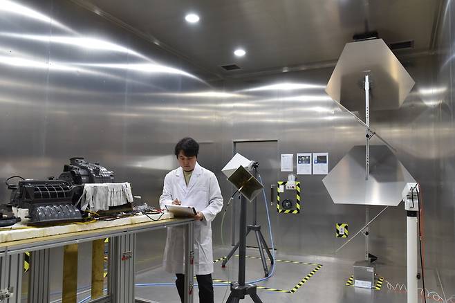 KTL 직원이 전기차(EV) 전장품을 대상으로 전자파잔향실(Reverberation Chamber)에서 고출력 전자파 내성시험을 수행하고 있다.