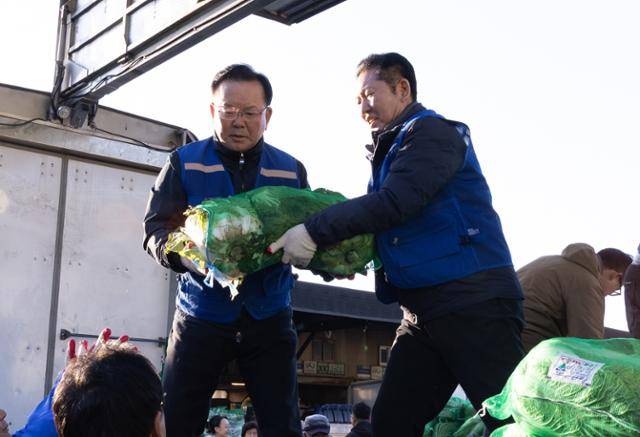 정청래(오른쪽) 더불어민주당 대표와 김부겸 민주당 대구시장 후보가 8일 대구 북구 매천동 농수산물도매시장에서 배추를 나르며 민생 현장 체험을 하고 있다. 더불어민주당 제공