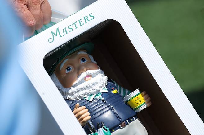 마스터스 관람객이 8일(현지 시간) 미국 오거스타 내셔널GC 골프숍에서 산 인기 굿즈 ‘놈’을 들고 이동하고 있다. 로이터연합뉴스