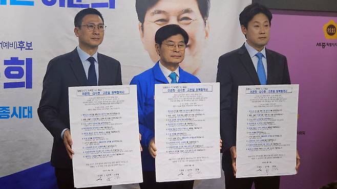 더불어민주당 세종시장 후보 결선 투표를 앞둔 이춘희 예비후보(가운데)가 13일 세종시의회 대회의실에서 김수현(왼쪽부터), 고준일 전 예비후보와 함께 정책협약을 체결한 뒤 기념촬영을 하고 있다. (사진=조선교 기자)