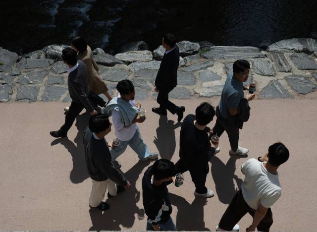 서울의 낮 최고기온이 25도까지 오르는 등 때 이른 초여름 날씨를 보인 13일 서울 청계천을 찾은 시민들이 아이스아메리카노 등 음료수를 들고 이동하고 있다. 연합뉴스