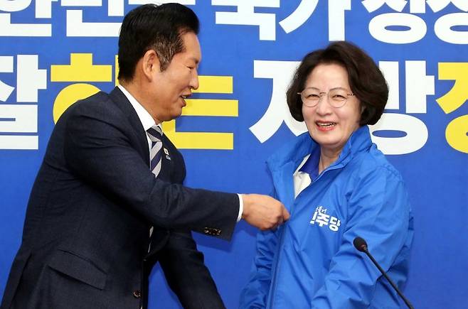 정청래 더불어민주당 대표가 13일 오전 서울 여의도 국회에서 열린 경기도지사 후보 환영식에서 추미애 후보에게 당 점퍼를 입혀주고 있다. 뉴시스