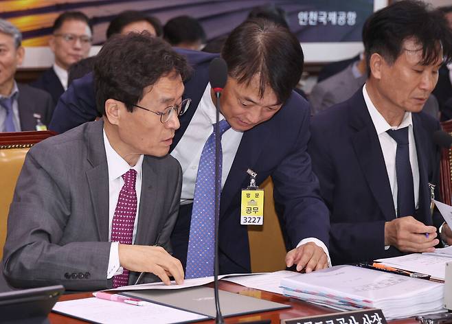 함진규 전 한국도로공사 사장(왼쪽)이 2025년 10월21일 오전 서울 여의도 국회에서 열린 국토교통위원회의 한국도로공사, 한국교통안전공단 등에 대한 국정감사에서 관계자와 이야기하고 있다. 윤운식 한겨레 선임기자 yws@hani.co.kr