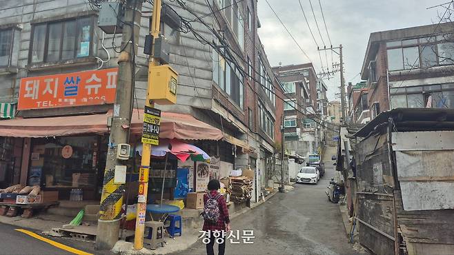 영화 <기생충>의 배경이 됐던 서울 마포구 아현동 아현1구역 돼지슈퍼 옆 골목으로 지난해 4월 13일 한 주민이 걸어가고 있다. 돼지수퍼는 현재 문을 닫았다. 류인하 기자