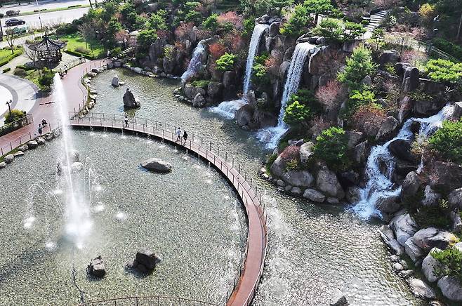 때 이른 초여름 날씨를 보인 13일 경기도 안산시 노적봉 폭포공원을 찾은 시민들이 시원하게 쏟아지는 폭포수를 바라보고 있다. [연합]