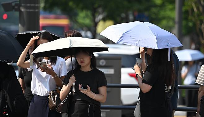 서울 종로구 세종대로 사거리에서 시민들이 양산으로 뜨거운 햇살을 가리며 출근길을 서두르고 있다. 임세준 기자
