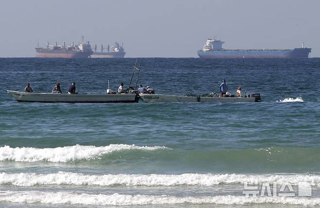 [AP/뉴시스]2012년 1월19일 호르무즈 해협 남쪽 아랍에미리트(UAE)의 라스 알 카이마 해안의 어선 뒤로 유조선 2척이 지나가고 있다. 프랑스 24는 이란이 호르무즈 해협 통제에 매달리는 이유에 대해 통행료 수입으로 전쟁으로 파괴된 인프라 재건 비용을 충당하고, 이를 지정학적 지렛대로 활용해 국제사회에서 발언권과 위상을 강화하려는 계산 때문이라고 설명했다. 2026.04.09.