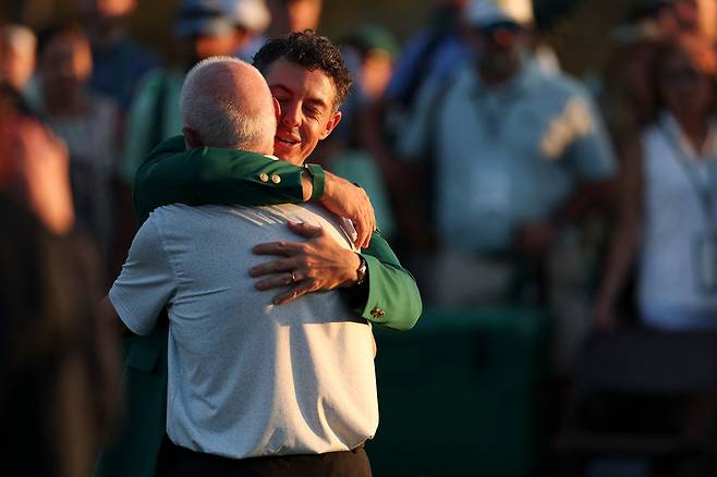 로리 매킬로이(오른쪽)가 12일(현지 시간) 미국 조지아주 오거스타 내셔널GC에서 진행된 제90회 마스터스 시상식에서 그린 재킷을 입고 아버지 제리와 포옹하고 있다. AFP연합뉴스