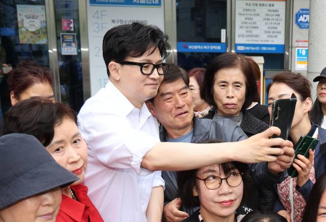 부산 북갑 보궐선거에 출마가 유력시되는 한동훈 전 국민의힘 대표가 14일 오후 부산 북구 만덕2동 행정복지센터에서 전입신고를 한 뒤 주민들과 기념사진을 찍고 있다. 정종회 기자 jjh@