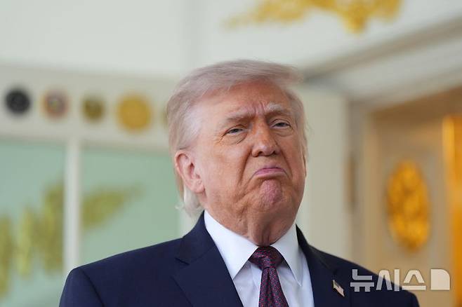 [워싱턴=AP/뉴시스] 도널드 트럼프 미국 대통령이 13일(현지 시간) 백악관에서 배달앱 '도어대시'의 샤론 시먼스로부터 맥도날드를 전달 받은 뒤 기자회견을 하고 있다. 2026.04.14.