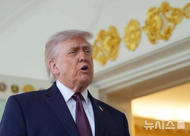 [워싱턴=AP/뉴시스] 도널드 트럼프 미국 대통령이 13일(현지 시간) 백악관에서 배달앱 '도어대시'의 샤론 시먼스로부터 맥도날드를 전달 받은 뒤 기자회견을 하고 있다. 2026.04.14.