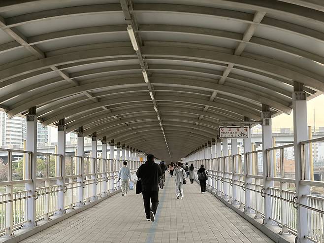 1호선 구일역에서 내린 시민들이 광명 방면 주거지로 가기 위해 안양천을 가로지르는 긴 보행 육교를 건너고 있다. 역사 자체가 안양천 위에 떠 있는 섬 같은 구조라, 열차에서 내려 집으로 향하는 길은 매일 아침저녁 ‘강제 행군’이 된다. 양다훈 기자