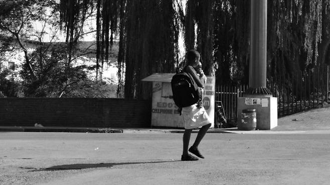 남아프리카공화국에서 어린 나이의 임신·출산 문제가 사회적 논란으로 번지는 가운데, 어린 소녀가 아이를 안고 거리를 걷고 있다. 조기 임신과 아동 보호 문제의 심각성을 상징적으로 보여주는 사진이다. Jan Truter·플리커