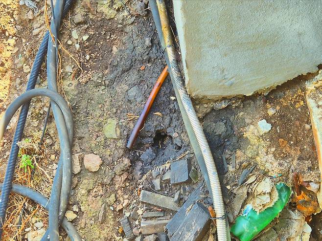 독도경비대 유류 저장시설 주변 토양 오염 실태. 어지럽게 널려진 배관과 전선 사이로 기름이 침투해 검은 자국이 선명하게 남아 있다. 경북경찰청의 “단순 작업 실수” 해명과 달리, 현장은 장기간 지속된 부실 관리 실태를 고스란히 드러내고 있다. /독자 제공