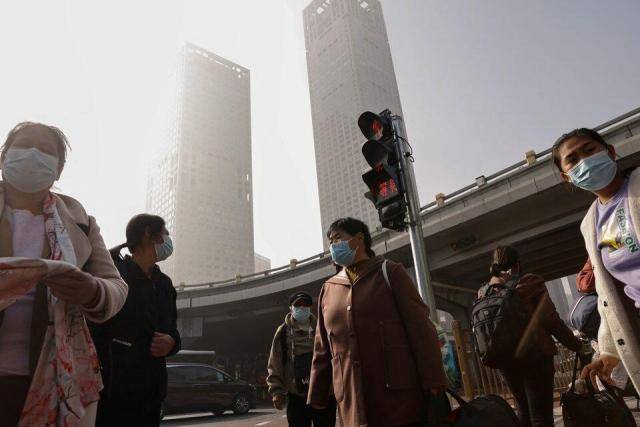 중국 베이징 하늘이 스모그로 뿌옇게 뒤덮인 가운데, 마스크를 착용한 시민들이 걸어가고 있다. [사진=로이터연합뉴스]
