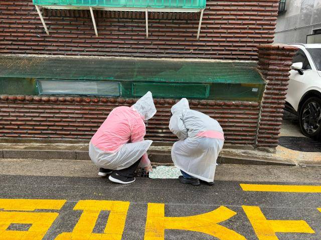 방학2동 모아센터의 마을매니저들이 빗물받이 상태를 점검하고 있다. [사진=이은별 기자]