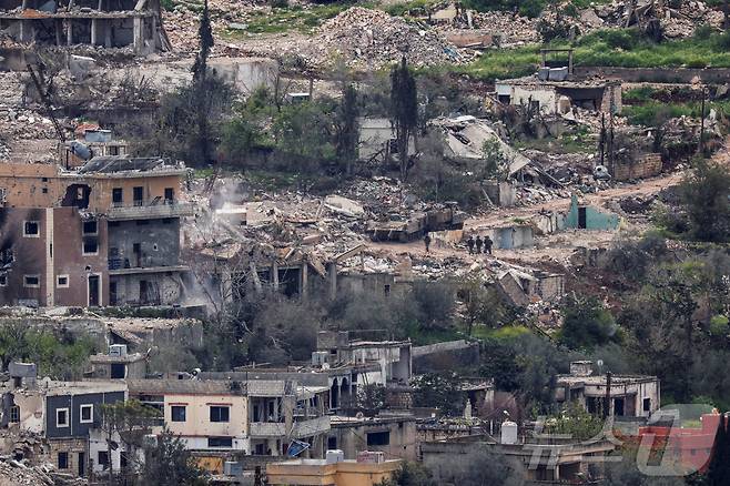 이스라엘군 병력이 14일(현지시간) 국경 인근 남부 레바논 지역에서 공습으로 파괴된 건물들 사이를 지나가고 있다. 2026.04.15. ⓒ 로이터=뉴스1