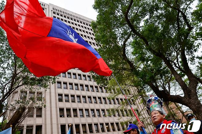 대만 타이베이 선거관리위원회 건물 밖에서 제1야당 국민당 지지자 국기를 흔들고 있는 모습. 2023.11.24. ⓒ 로이터=뉴스1