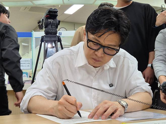 한동훈 전 국민의힘 대표가 부산 북구 만덕2동 주민센터에서 전입신고서에 서명하고 있다. /뉴스1