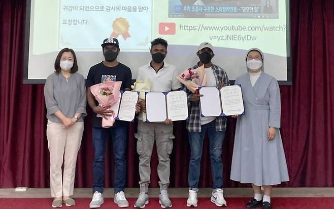 2022년 9월 4일 조종사를 구한 공로로 화성시 외국인복지센터장 표창장을 받은 루완 씨(가운데)와 동료들이 사진을 찍고 있다. (사진=화성시 외국인복지센터 제공). 뉴시스