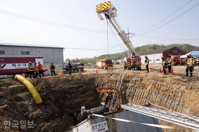 15일 경기 하남시 교산 공공주택지구에서 열린 2026년 중대재난대응 유관기관 합동훈련에서 경기119특수대응단 특수구조팀원들이 중장비 특수차량을 활용해 싱크홀 매몰자를 구조하고 있다. 하남=강예진 기자