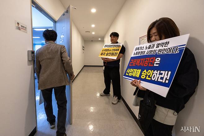 3월31일 광주질병판정위원회가 열리기 전 박정현씨 유족을 돕는 이들이 산재 승인을 요구하는 피켓을 들고 서 있다. ⓒ시사IN 조남진