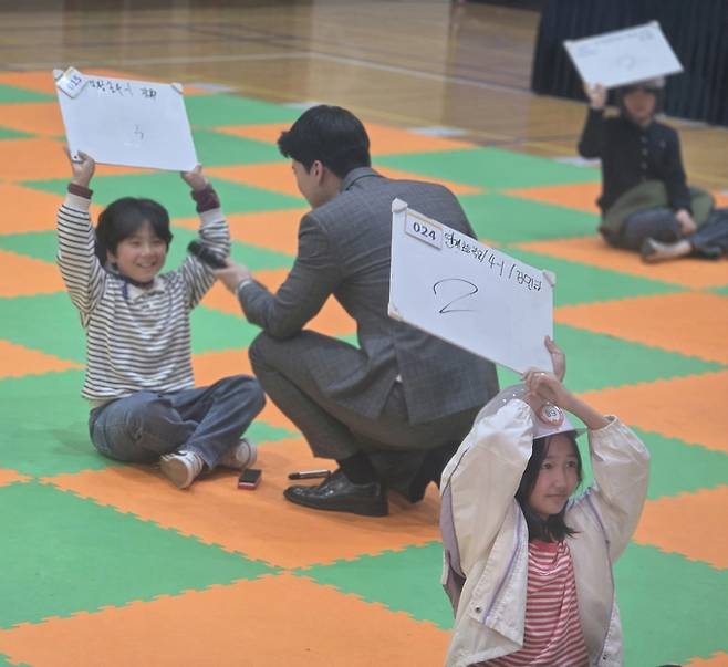 ▲ '2026 안전골든벨 경상북도 어린이퀴즈쇼' 의성 예선 27번 문제에서 김지훈 아나운서가 참가 학생들의 답안을 확인하고 있다. 한 참가자는 홀로 다른 답을 적어 탈락했지만 밝은 표정으로 웃으며 결과를 받아들이고 있다.김동현 기자 jhass80@kyongbuk.com