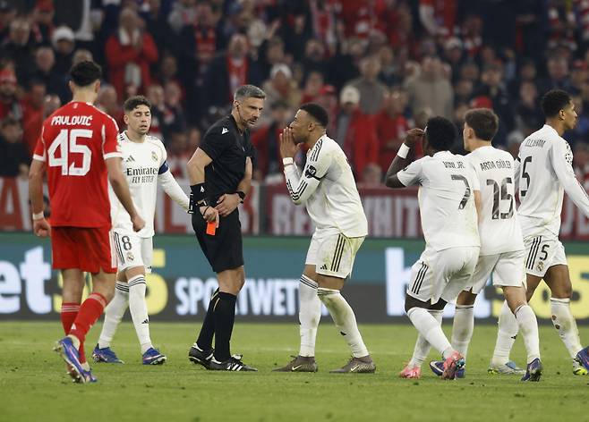 Soccer Football - UEFA Champions League - Quarter Final - Second Leg - Bayern Munich v Real Madrid - Allianz Arena, Munich, Germany - April 15, 2026 Real Madrid's Kylian Mbappe, Vinicius Junior and Arda Guler remonstrate with referee Slavko Vincic after Real Madrid's Eduardo Camavinga was shown a red card REUTERS/Michaela Stache







<저작권자(c) 연합뉴스, 무단 전재-재배포, AI 학습 및 활용 금지>