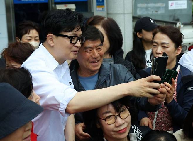 한동훈 전 국민의힘 대표가 부산 북구 만덕2동 주민센터에서 전입신고를 마친 이후 주민들과 사진을 찍고 있다. 연합뉴스 제공