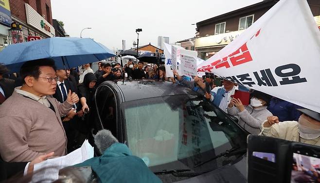 지난해 5월 13일 경북 고령 영남신라벨트 인근 대선 유세 중인 당시 이재명 대통령 후보가 대구 내당3지구 지역주택조합원들과 이야기하고 있다. /연합뉴스