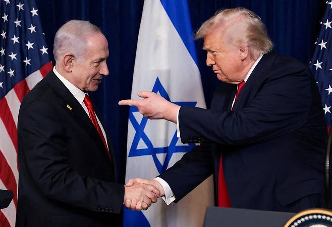 지난해 12월29일 미국 플로리다주 팜비치의 마러라고 클럽에서 도널드 트럼프 미국 대통령이 베냐민 네타냐후 이스라엘 총리와 회담 후 열린 기자회견에서 악수하며 손가락으로 가리키고 있다. 로이터 연합뉴스