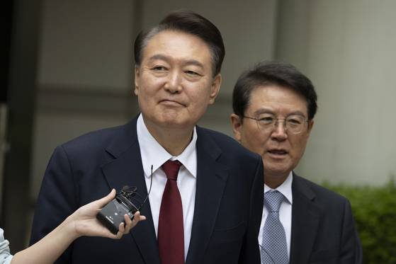 2025년 5월 당시 윤석열 전 대통령이 윤갑근 변호사(오른쪽)와 함께 서울 서초구 중앙지방법원에서 열린 내란 우두머리 혐의, 직권남용 권리행사방해 혐의 사건 4차 공판의 오전 재판 종료 후 점심 식사를 위해 나서고 있다.