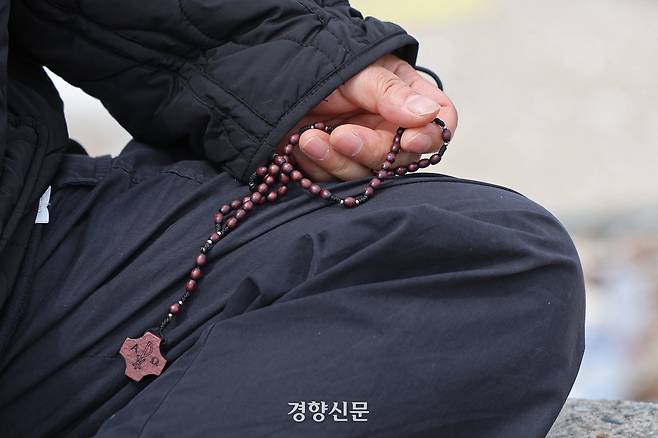 세월호 참사 유가족인 정정희씨가 12일 고향인 전남 목포시 달리도의 세월호 선체가 보이는 바다 앞에서 묵주를 만지고 있다. 정효진 기자