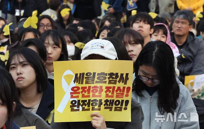 [서울=뉴시스] 최진석 기자 = 지난 11일 서울 숭례문 인근에서 열린 세월호 참사 12주기 기억약속 시민대회에서 참가자가 피켓을 들고 있다. 2026.04.11. myjs@newsis.com