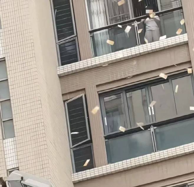 [서울=뉴시스] 중국 광둥성 산터우의 한 아파트 단지에서 여성이 창문 밖으로 돈을 뿌리는 영상이 공개돼 화제가 되고 있다. (사진=웨이보)
