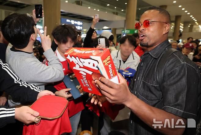 [인천공항=뉴시스] 황준선 기자 = 전 프랑스 축구 선수 파트리스 에브라가 16일 오후 인천국제공항 1터미널을 통해 방한해 팬에게 초코파이를 선물받고 있다.에브라는 축구 콘텐츠·이벤트 제작사 '슛포러브'가 기획한 OGFC(더 오리지널 FC)에 합류해 오는 19일 프로축구 K리그2 수원삼성 레전드 팀과 경기를 치른다. 2026.04.16. hwang@newsis.com
