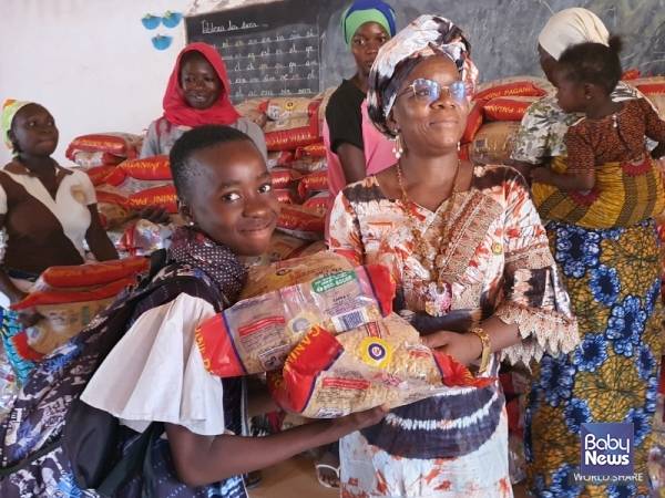 아동이 마카로니 포대를 받아들고 환히 웃고 있다. ⓒ월드쉐어