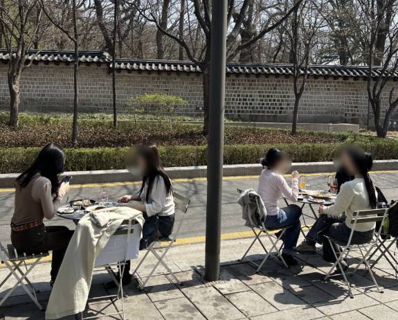 People dine outdoors at Seosulla-gil in Jongno District. [SCREEN CAPTURE]