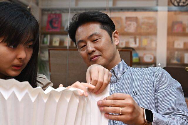 이효건(오른쪽) 한국조폐공사 차장이 지난 9일 서울 마포구에 위치한 친환경 기업 ‘그레이프랩’ 사무실에서 화폐 부산물을 첨가한 종이로 노트북 거치대를 만들고 있다. 윤웅 기자