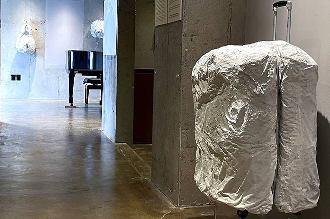 가방 형태의 오브제가 시멘트로 고정돼 전시장에 설치돼 있다. (양종훈 갤러리 제공