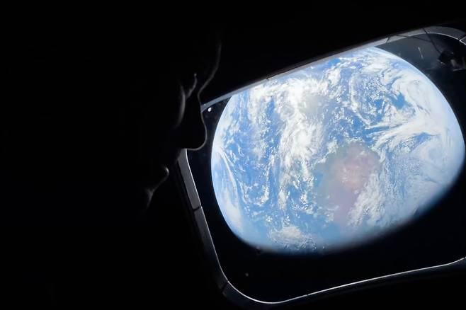 달로 향하는 아르테미스Ⅱ임무 중 리드 와이즈먼 우주비행사가 지난 2일(현지시간) 우주선 창문을 통해 지구를 내려다보고 있다. NASA가 공개한 이 사진에는 옅은 초록빛 오로라가 포착됐다. AP=연합뉴스