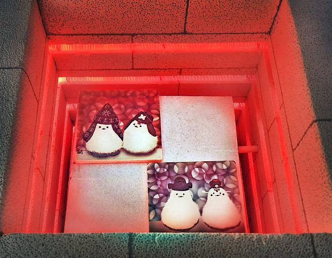 Ceramic paintings undergo firing in an electric kiln. [PARK SANG-MOON]