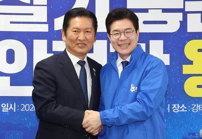 정청래 더불어민주당 대표가 17일 오전 서울 용산구 강태웅 용산구청장 후보 사무소에서 열린 현장 최고위원회의에서 정원오 서울시장 후보에게 당 점퍼를 입혀준뒤 손을 잡고 있다. /사진=뉴스1