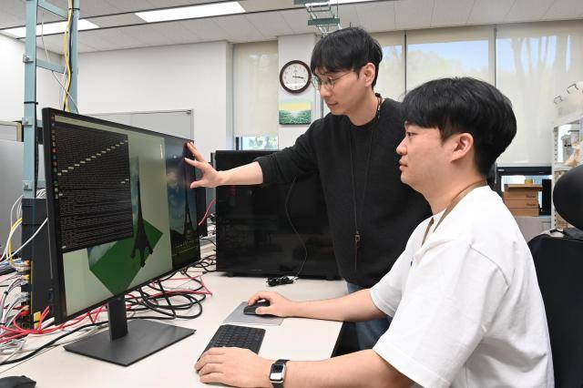 ETRI 연구진이 USD 기반 미디어 트랜스포메이션 기술 시연 화면을 보며 개발 내용을 논의하고 있다. [사진=ETRI]