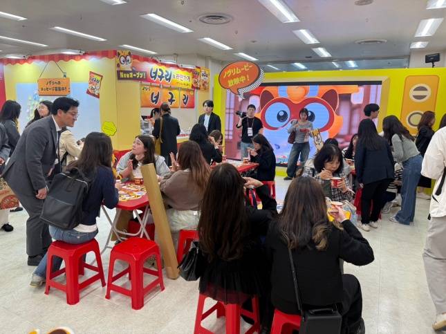 코리아 엑스포 2026 도쿄에 열린 농심 너구리 부스에서 너구리를 맛보고 있는 사람들/사진=김다이 기자 @neverdie