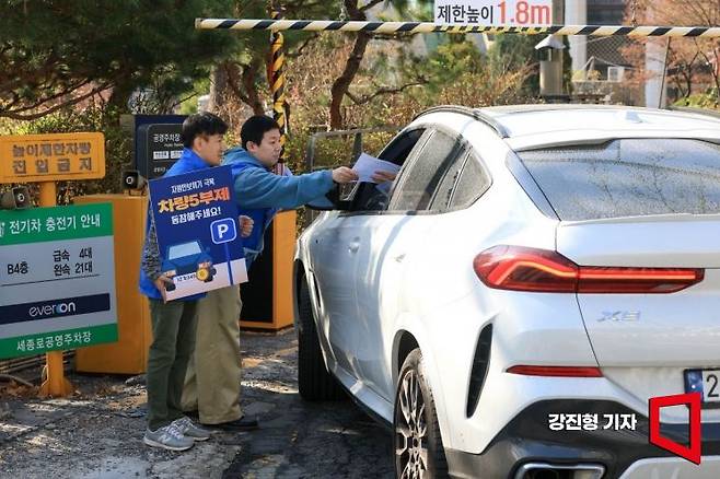 중동전쟁 장기화에 따라 공공기관이 운영하는 공영주차장 5부제가 시행된 지난 8일 서울 종로구 세종로공영주차장 입구에서 직원들이 운전자들에게 5부제 시행 안내를 하고 있다. 2026.4.8 강진형 기자