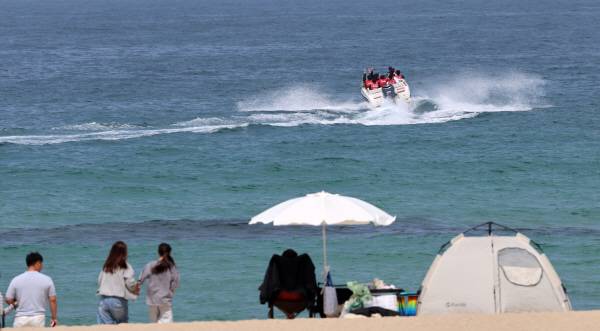 19일 강원 강릉시 안목해변에서 관광객들이 모터보트를 타고 시원한 바다를 가르며 앞당겨 찾아온 더위를 식히고 있다. 연합뉴스